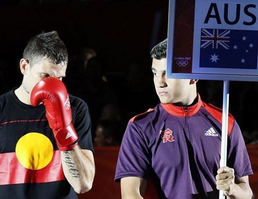 Damien Hooper (L) of Australia is dressed in a T-shirt bearing the Aboriginal colours